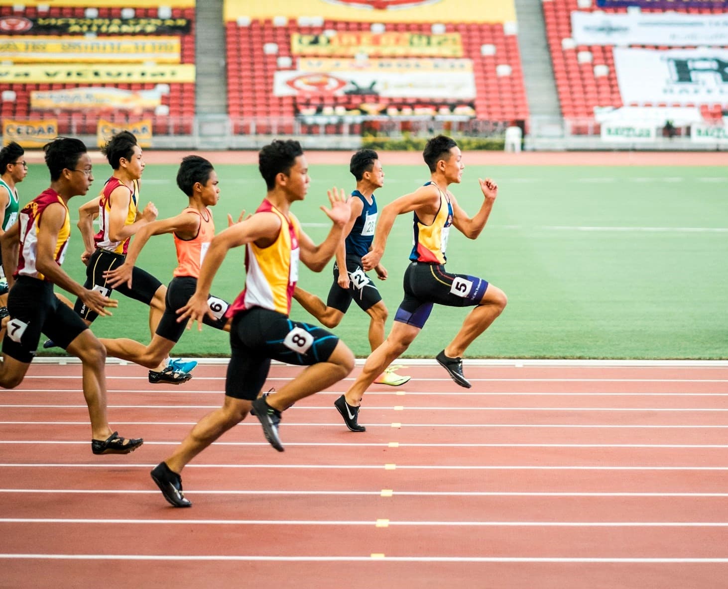 Gruppe von Männern, die auf dem Leichtathletikfeld laufen